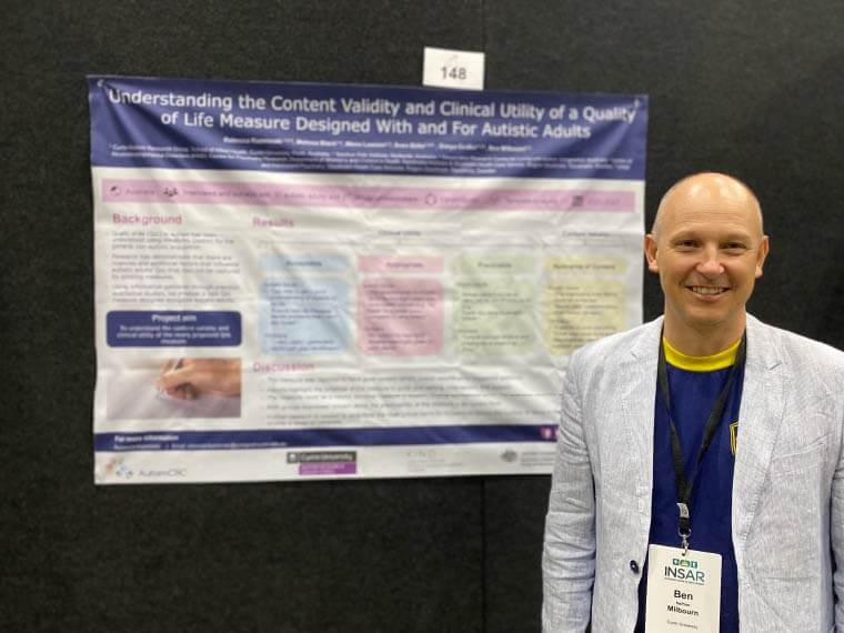 A researcher stands in front of poster