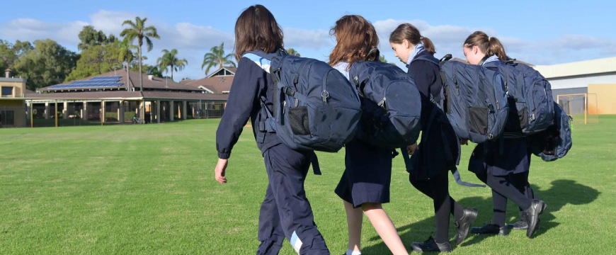 A group of students walking across a lawn